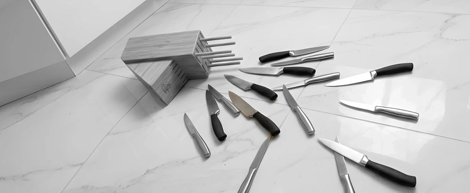Image: A fallen tray of prop knives lying on the floor, knives scattered near it
