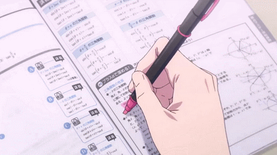 This may contain: a hand holding a pen in front of an open book with japanese characters on it