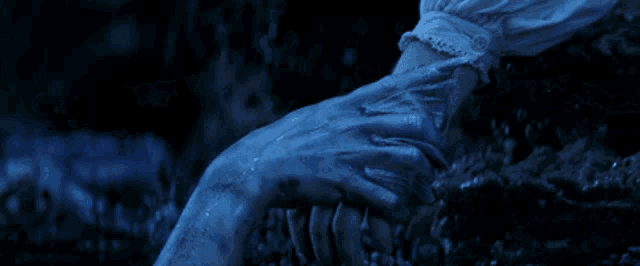 a close up of a person holding another person 's hand in the dark